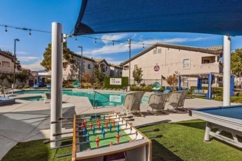Outdoor game space featuring billiards, foosball, and firepits with lounge seating
